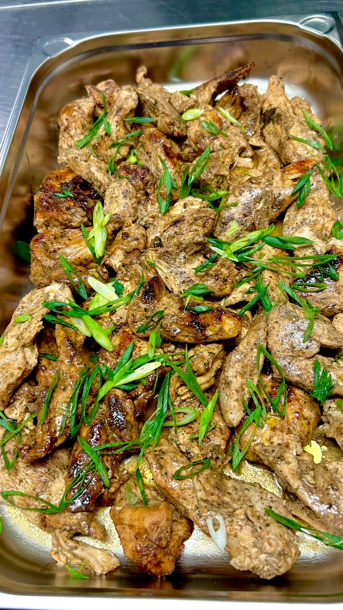 Gegrilltes Hähnchenfleisch mit frischen grünen Zwiebeln auf einem Tablett